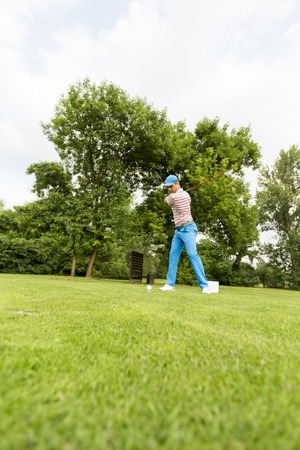Young man playing golf on the golf courseの写真素材