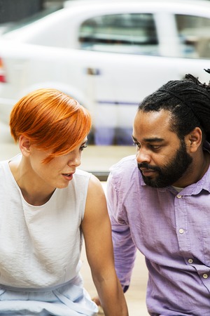Redhaired young woman and black guy talkingの写真素材