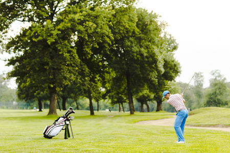 Young man playing golf on the golf courseの写真素材