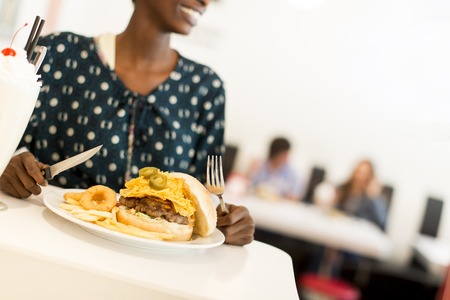 Young african american woman eating in the dinerの写真素材
