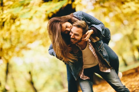 Young couple having fun in the autumn parkの写真素材