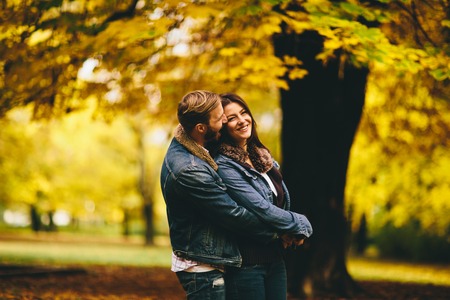 Young couple posing in the autumn parkの写真素材