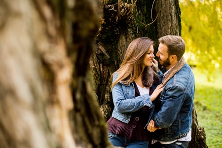 Loving couple exchanging tenderness in the autumn parkの写真素材