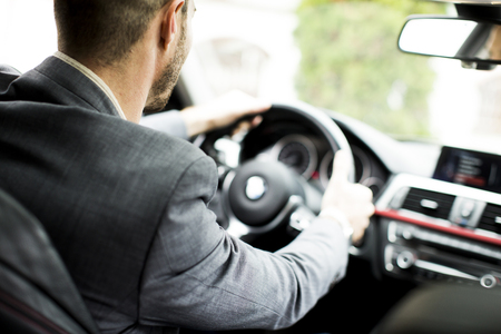 Young businessman driving car