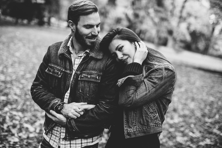 Young loving couple having a walk in the autumn parkの写真素材
