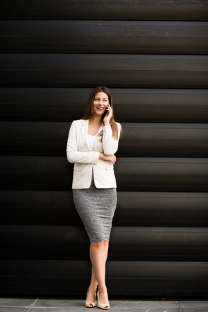 Beautiful young business woman calling by phone and smilingの写真素材