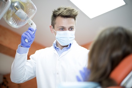 Woman patient talking to male dentist and complain of toothache at dental clinic officeの写真素材