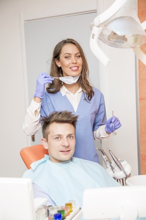 Young man having medical checkup in the dentist office by the young doctorの写真素材
