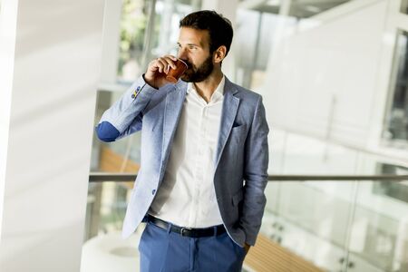 Business man in a business suit and a cup of coffee in a  office building.の写真素材