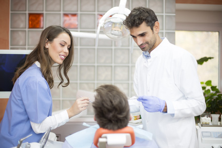 Young man having medical checkup in the dentist office by male and female doctorsのeditorial素材