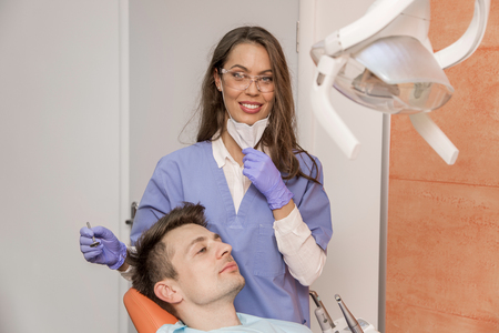 Young man having medical checkup in the dentist office by the young doctorの写真素材