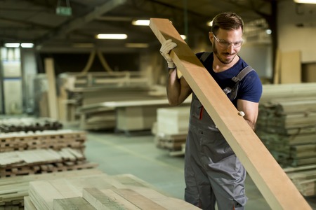 Young worker works in a factory for the production of furnitureの写真素材