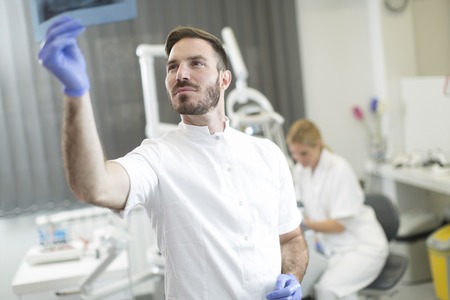 Dentist analyzing x-ray of teethの写真素材