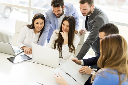 Startup business team on meeting in modern bright office interior and working on laptop