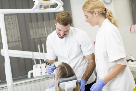 Young woman getting dental treatment in dentist officeの写真素材