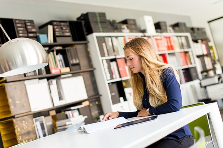 Young businesswoman  analyzes document in the office
