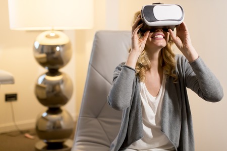 Woman wearing virtual reality goggles in the roomの写真素材