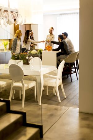 Group of young friends toasting with white wine joyous eventの写真素材