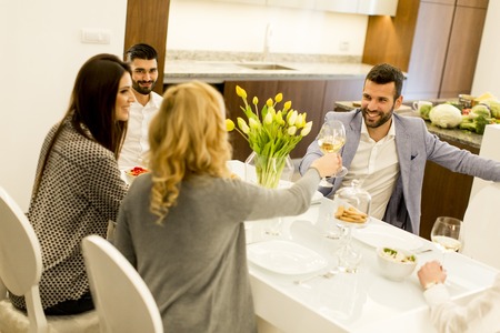 Young people have dinner and toasting white wine