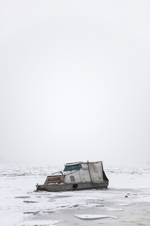 View at the boat at frozen ice river in the winterの写真素材