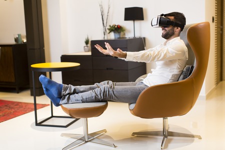 Young guy in virtual reality headset playing game