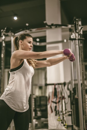 Young woman exercise with weights at the gymの写真素材