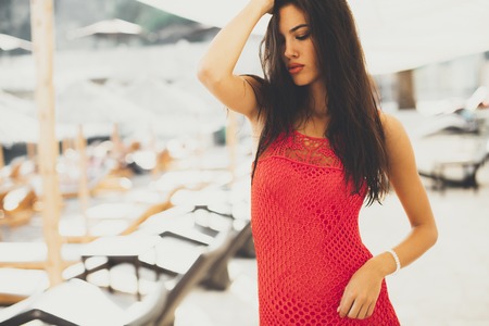 Young woman posing outside at summer in a red dressの写真素材