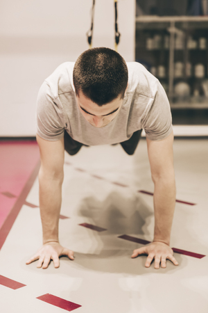 Young man doing push-ups in the gymの写真素材