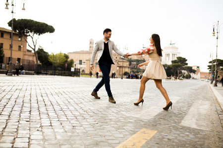 Casual young couple holding hands walking in Rome, Italy, Europe.の写真素材
