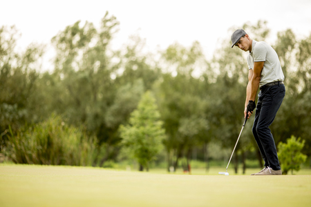 Young man playing golf on the golf courseの写真素材