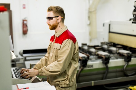 Young man working in the furniture factory