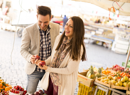 Young couple buying vegetables on a marketの写真素材