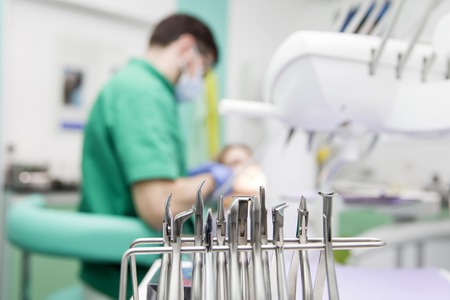 Close-up picture of young lady having her teeth examined by a dentist at dentist's officeの写真素材