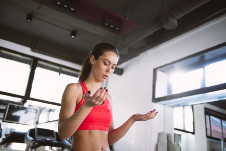 Young woman powder hands before exercise in the gymの写真素材
