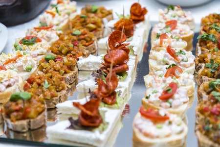 Colorful canape with vegetables and sausage on plate. Tasty appetizer for party or banquetの写真素材