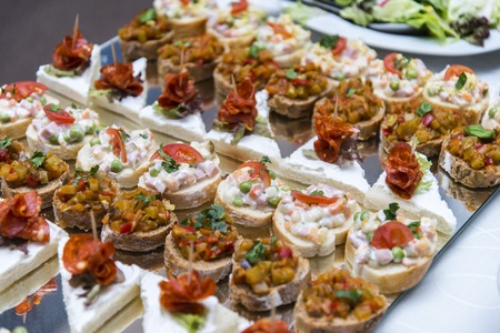 Colorful canape with vegetables and sausage on plate. Tasty appetizer for party or banquetの写真素材