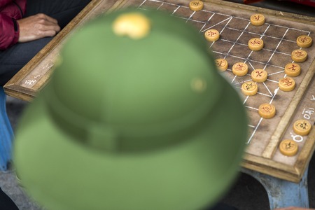 HALONG, VIETNAM - FEBRUARY 28, 2017: Unidentified man playing traditional Chinese chess on Halong sidewalk in Vietnam. It is one of the most popular board games in China.のeditorial素材