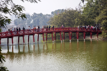HANOI, VIETNAM - MARCH 2, 2017: Unidentified people at Huc bridge in Hanoi, Vietnam. This wooden red bridge connect Jade Island with shore  at Hoan Kiem lake.のeditorial素材