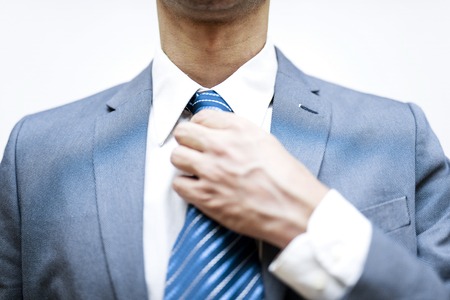 Young businessman adjusts his tieの写真素材
