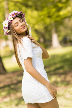 Pretty young woman with flowers in her hair on sunny spring dayの写真素材