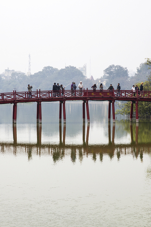 HANOI, VIETNAM - MARCH 2, 2017: Unidentified people at Huc bridge in Hanoi, Vietnam. This wooden red bridge connect Jade Island with shore  at Hoan Kiem lake.のeditorial素材