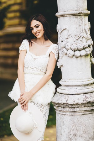 Pretty young woman in white dress on the streetの写真素材