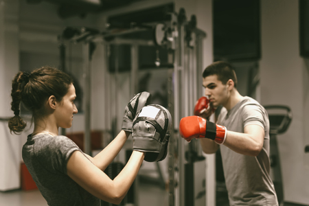 Young man have boxing training with woman assistant