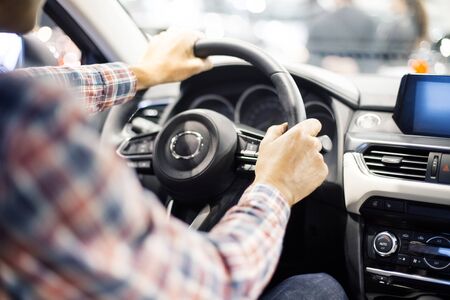 View at young handsome man driving modern car