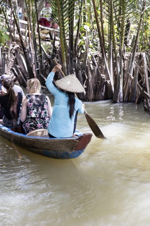 MEKONG DELTA, VIETNAM - FEBRUARY 21, 2017: Unidentified people in the boat at Mekong Delta in Vietnam. Boats are the main means of transportation in Mekong Delta.のeditorial素材