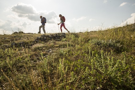 Couple backpackers hiking on the path in mountains during summerの写真素材