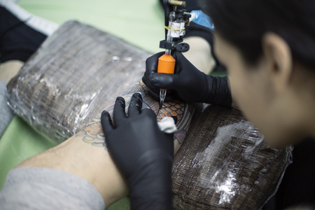 BELGRADE, SERBIA - MAY 2, 2017: Unidentified woman making tattoo in Belgrade, Serbia. First documented professional tattooist was Sutherland Macdonald in the early 1880のeditorial素材