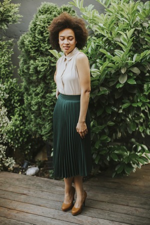 View at curly hair young woman standing in the courtyardの写真素材