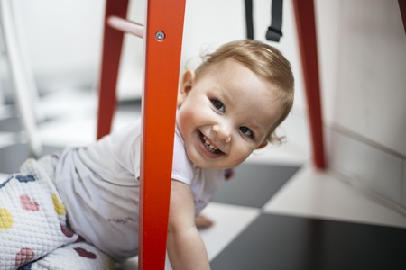 Portrait of a young smiling girl playing at homeの写真素材