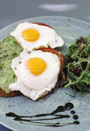 Close up view at fresh breakfest, fried eggs and salad on plate